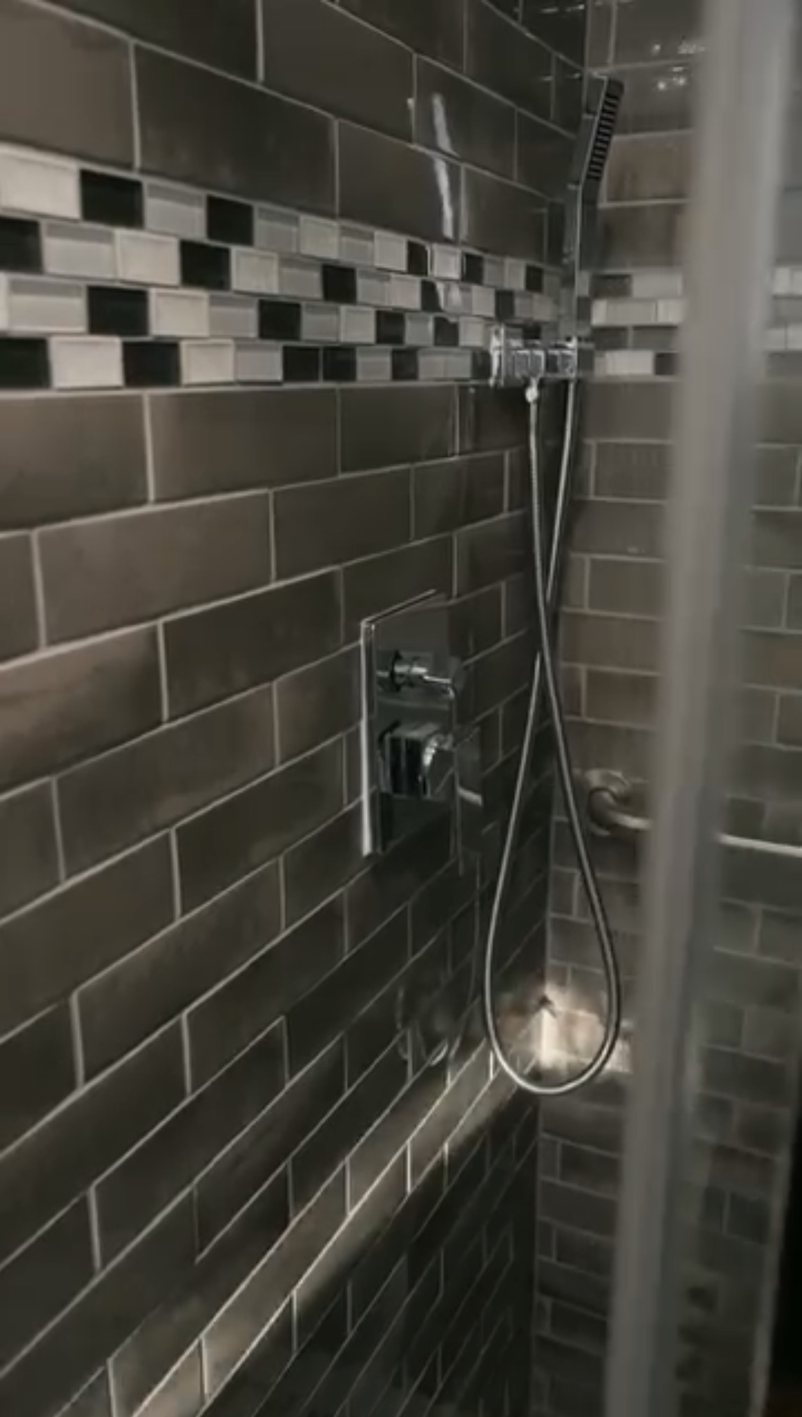 Finished shower remodel — dark subway tile and chrome fixtures